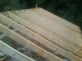 New roof rafters set over an addition before sheathing in Slaterville Springs