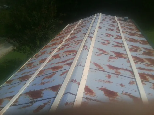 Rusted metal roof panels with new wood purlins before replacement — Storm Damage Roof Repair in Slaterville Springs by Roofing Brothers
