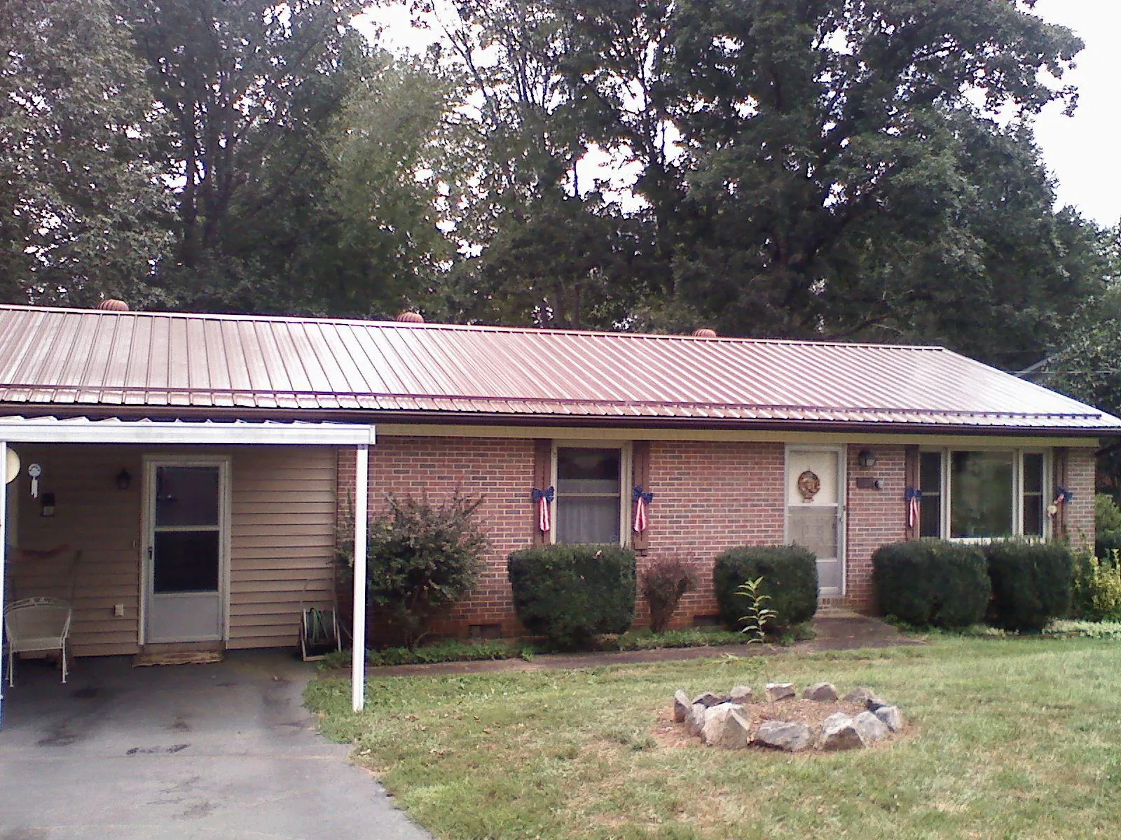 Bronze metal roof and carport on a brick ranch home — Roof Repair work by our crew in Slaterville Springs