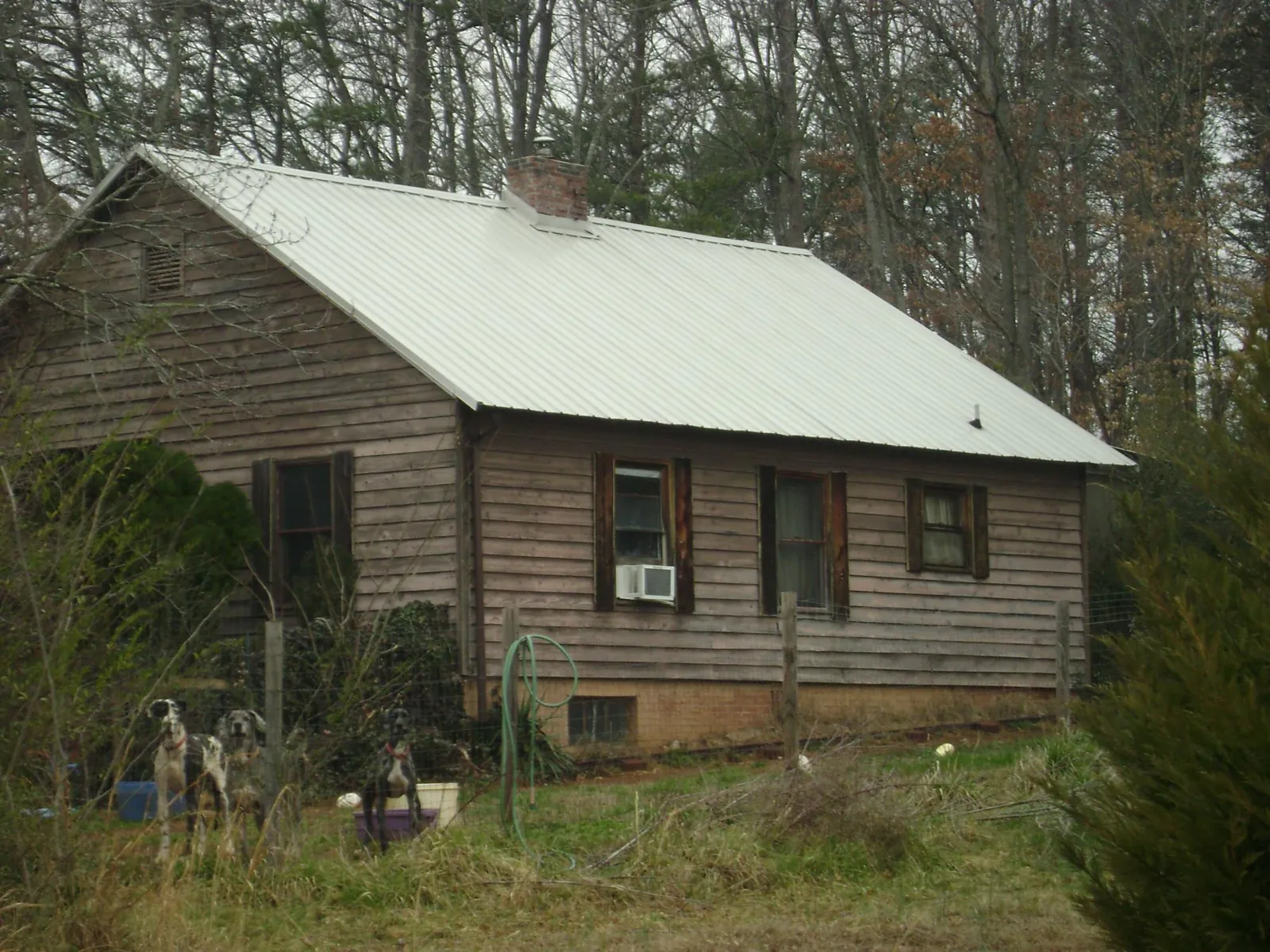 White metal roof on an old wood sided farmhouse, from a Metal Roof Installation job in Slaterville Springs